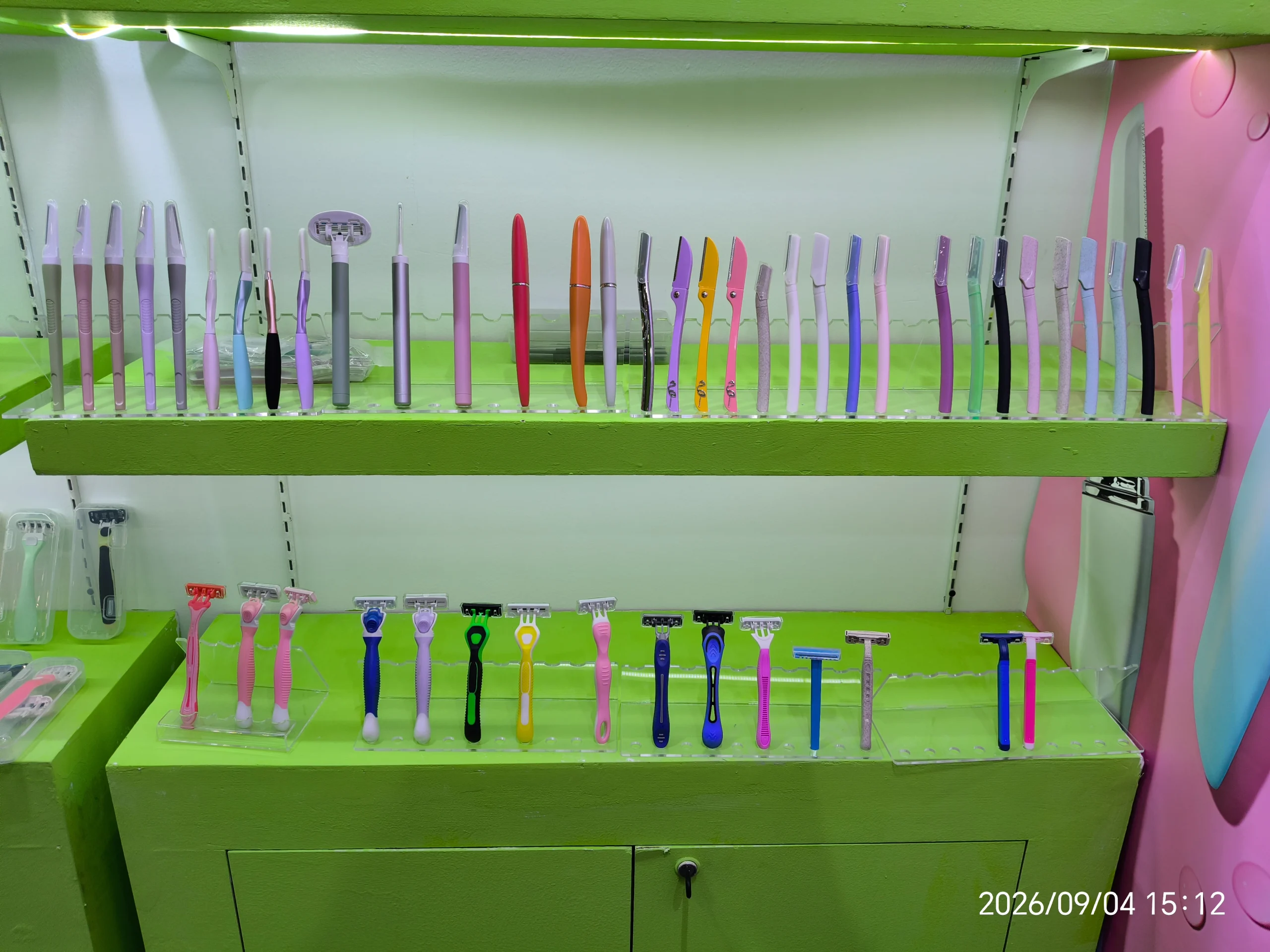 Des rasoirs à sourcils, des rasoirs pour le visage et des rasoirs pour femmes exposés sur les étagères du stand Haward Razor.